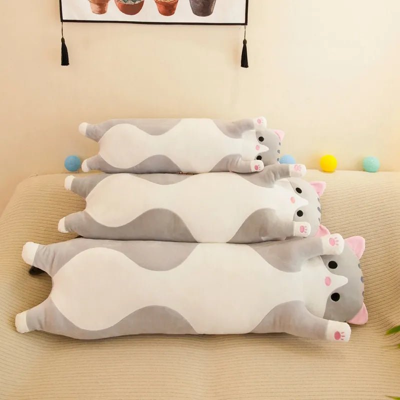Set of cat-shaped cushions on a beige surface.