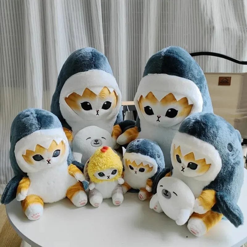 Set of plush toys resembling penguins with cat faces on a white surface.