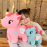 Person holding two plush unicorns