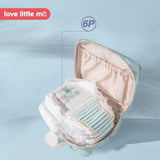 Diaper bag with baby diapers inside on a light blue background, featuring the 'love little m' brand.