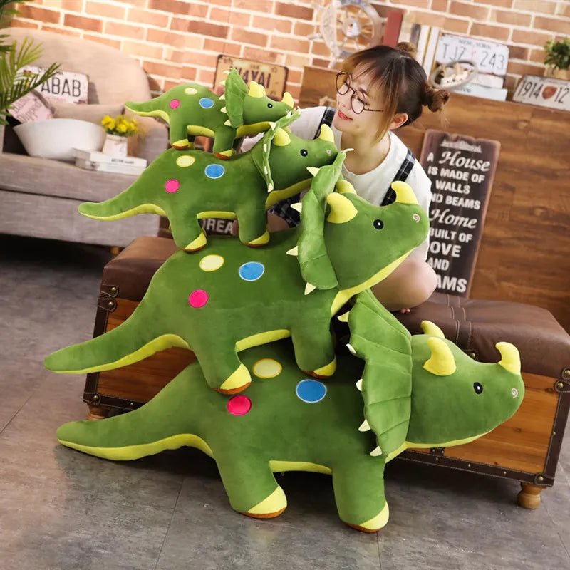 Person holding a large green plush dinosaur toy in a living room setting.