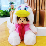 Plush toy with a white hood, yellow beak, pink scarf, and black eyes on a wooden surface.