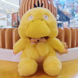 Yellow plush toy with a small person inside, held by a hand in an indoor setting.