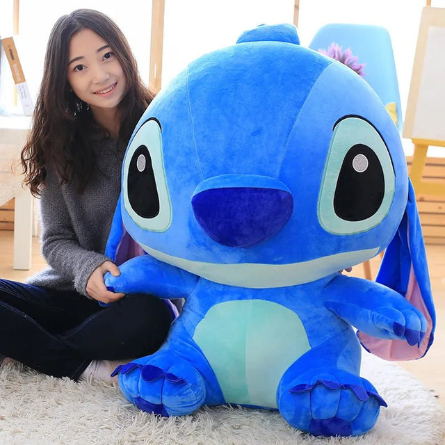 A person holding a large blue plush toy 