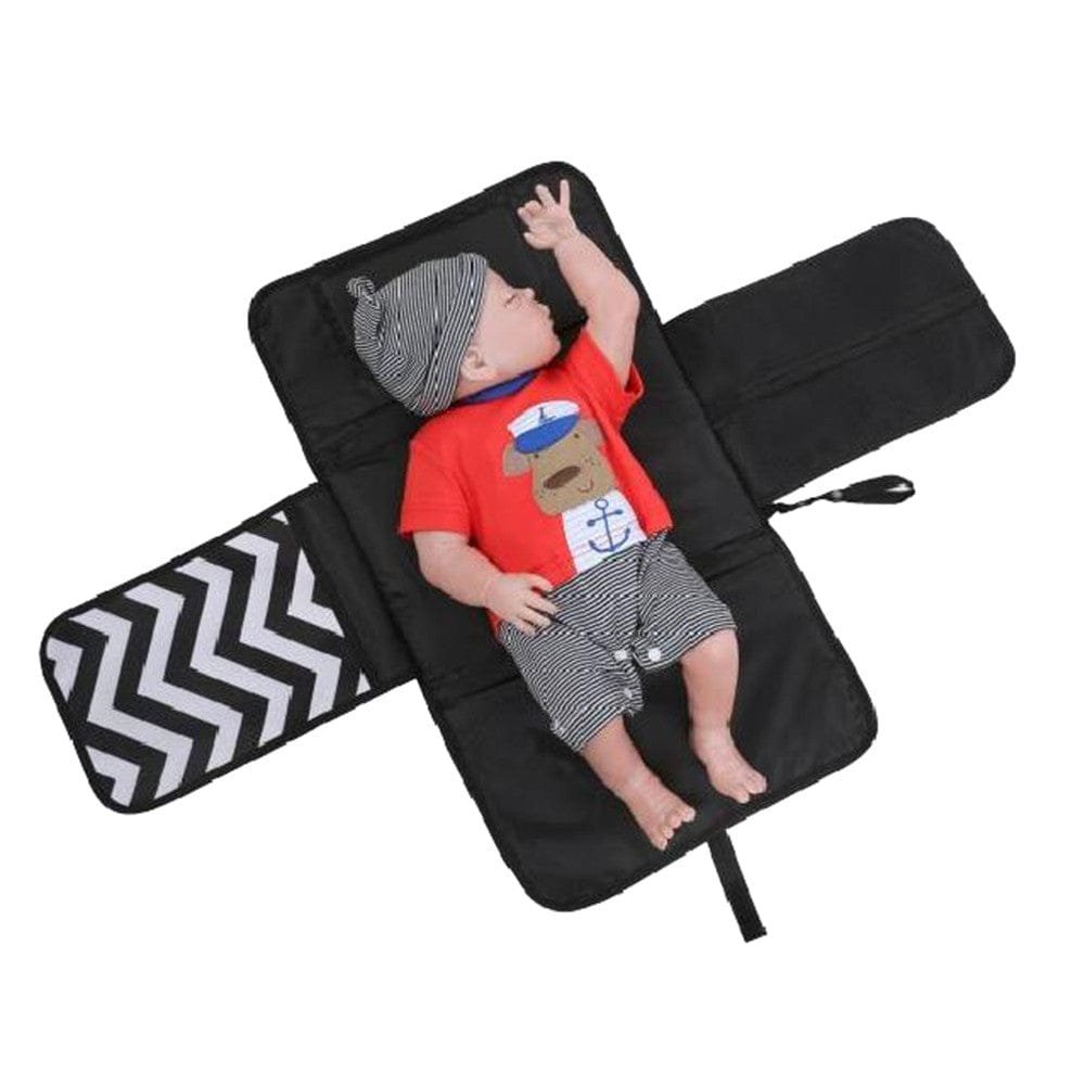 Black diaper bag with a chevron pattern showing a baby wearing a red shirt and gray shorts.