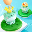 Two frog-shaped bath toys on green platforms.