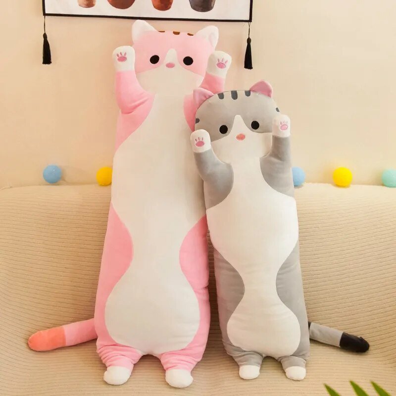 Two cat-shaped plush toys on a beige couch with colorful balls.
