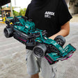 Person holding a detailed model of a racing car with 'AEEIX' branding 