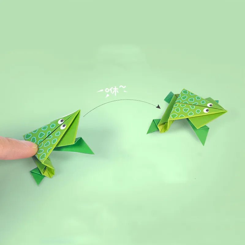 Two origami frogs on a light green background