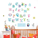 Colorful alphabet letters on a white wall above a crib with educational toys.