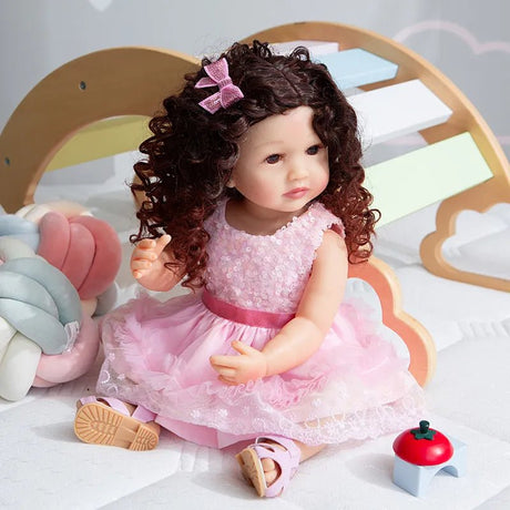 A doll with curly hair and a pink dress 