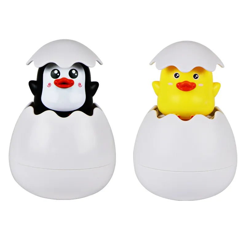 Two small animal figures, a penguin and a duck, inside eggshells.