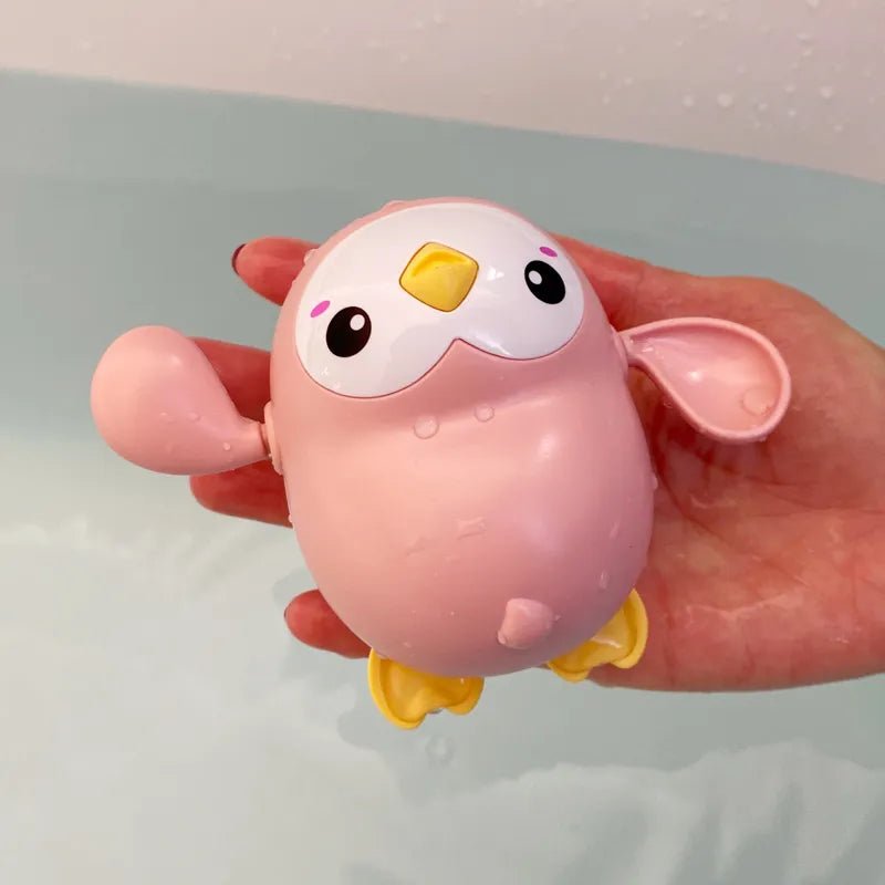 Pink cartoon-like bird toy held in a hand.