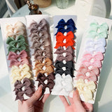 Set of colorful hair bows on display with a hand holding one bow.