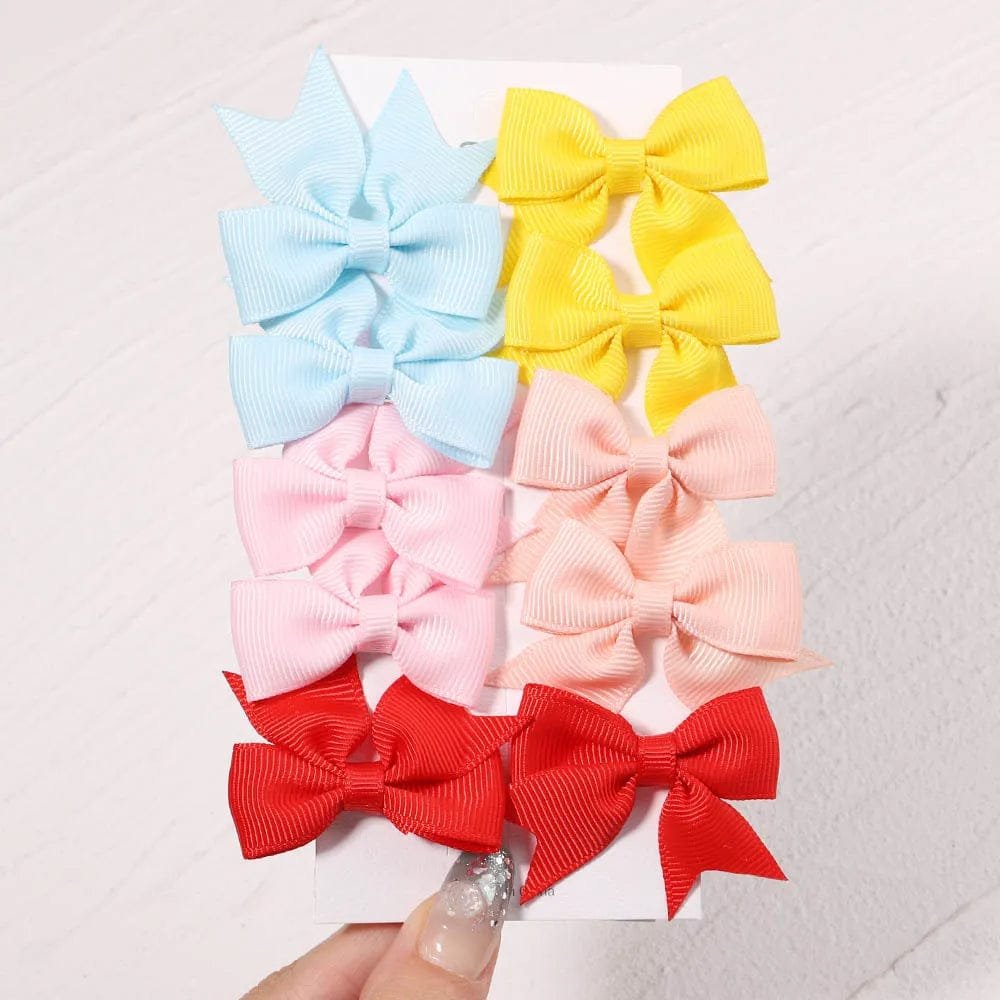 Set of colorful hair bows on a textured white background