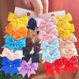 Assorted colorful hair bows on a white card held by a hand