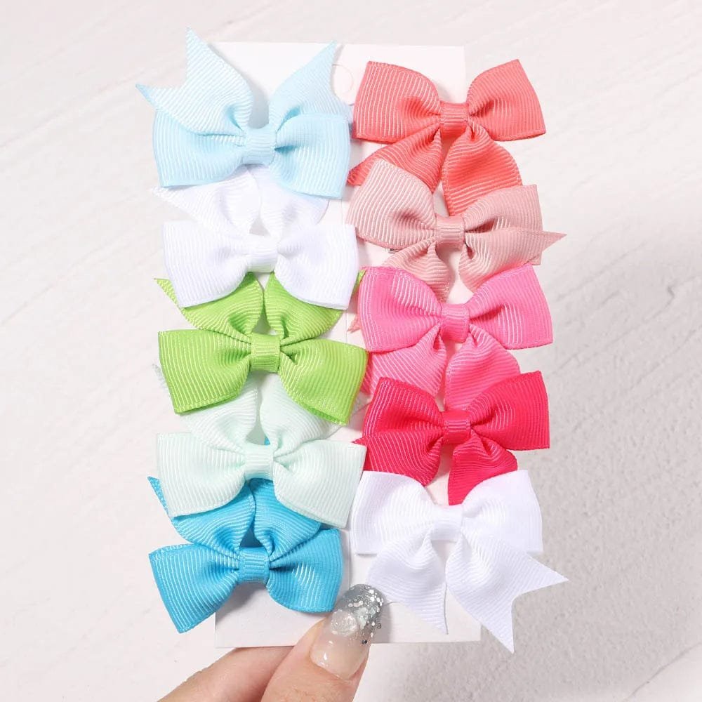 Set of colorful hair bows on a textured white background