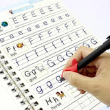 Handwriting practice book with letters E, F, G, and H being written by a hand holding a pen.