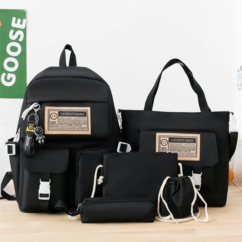 Set of black bags with visible branding on a light wooden surface.