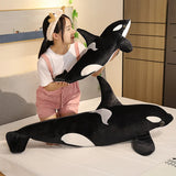 Child holding a large plush orca whale toy in a bedroom setting