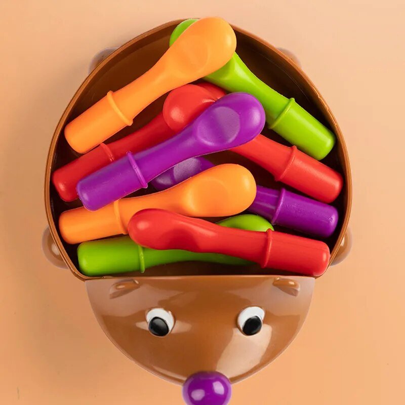 Colorful plastic spoons in a brown container shaped like a Hedgehog.