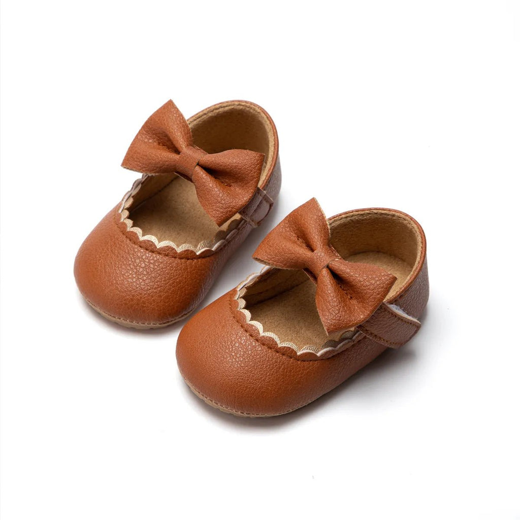 Pair of brown leather baby shoes with bows 