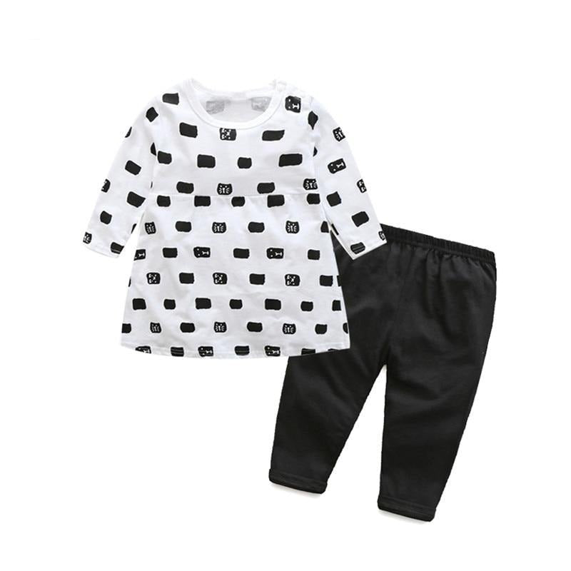 Children's outfit with white dress with black pattern and black pants 