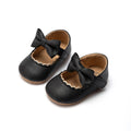 Pair of black leather shoes with bows 