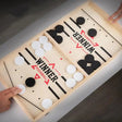 Wooden foosball table game with black and white balls.