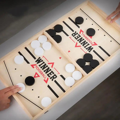 Wooden foosball table game with black and white balls.