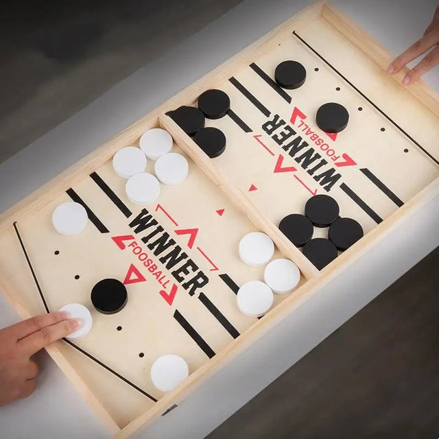 Wooden foosball table game with black and white balls.