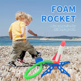 Two children playing with a foam rocket on a pebbly beach.