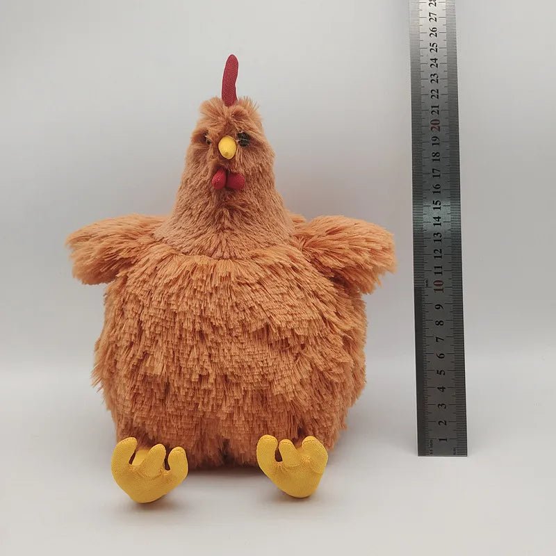 Plush chicken toy next to a ruler on a white background