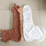 Brown and white llama-shaped bath towels on a tiled floor