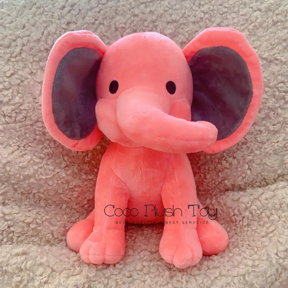 Pink plush elephant toy on a beige carpet with 'Coco Plush Toy' branding.