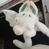 Plush toy with bunny-like features on a dark surface