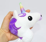 Plush unicorn toy with a rainbow horn held in a hand.