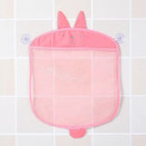 Pink bath toy with bunny ears hanging on a tiled wall