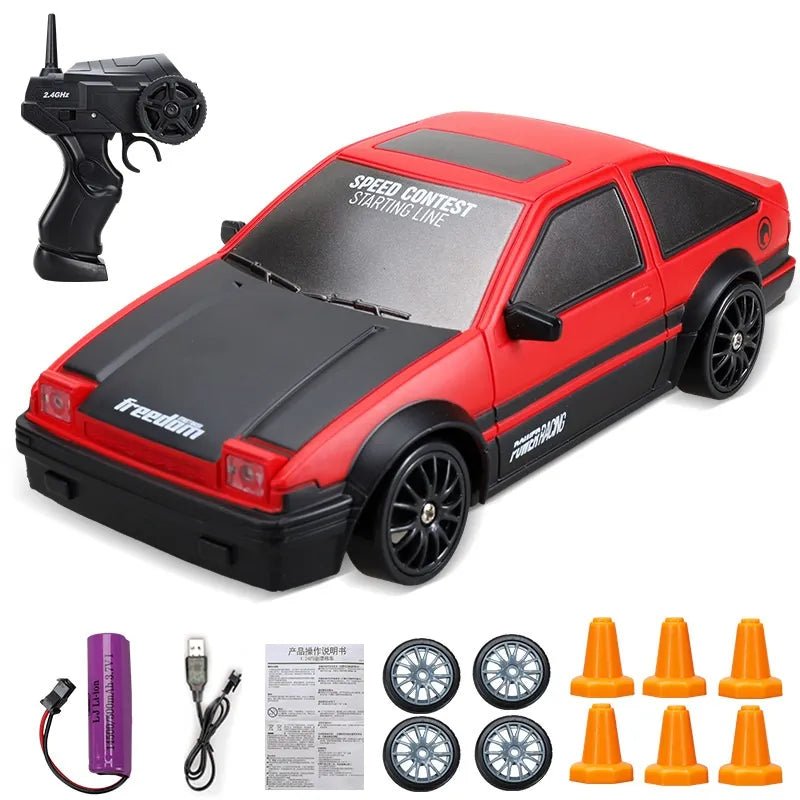 Red and black toy car with remote control, batteries, and cones.