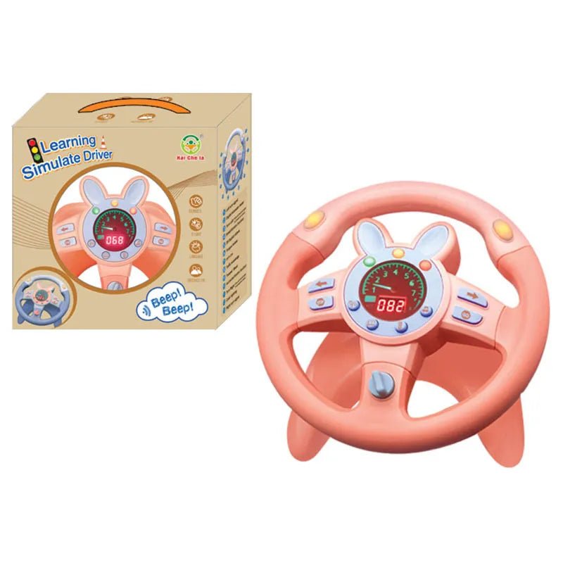 Pink toy steering wheel with digital display and buttons, next to its packaging 