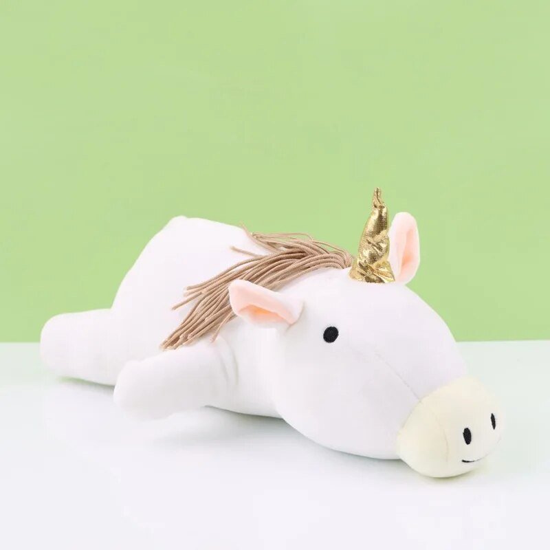 White unicorn plush toy with a gold horn on a light green background