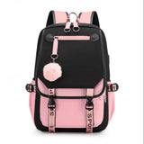 Black and pink backpack with a pom-pom charm.