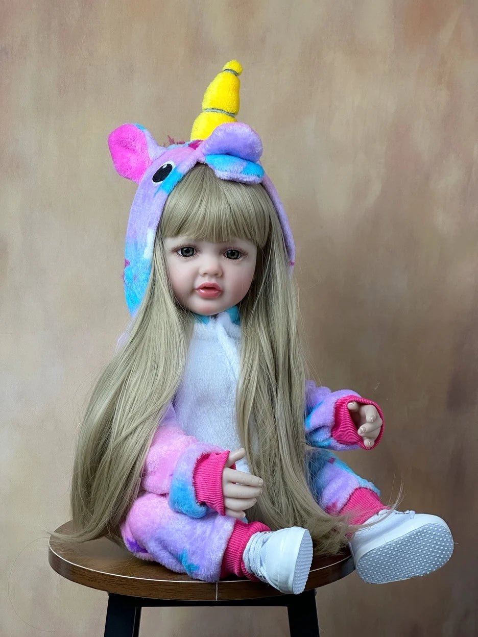 Unicorn-themed doll with colorful outfit sitting on a wooden stool 