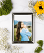 Framed photo of a woman holding a baby with decorative flowers.