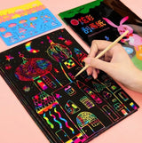 Scratch art kit with colorful designs on a black surface.