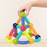 Colorful magnetic building toy being held by a hand