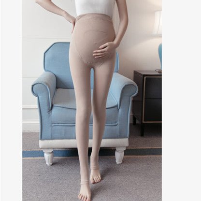 A person wearing beige compression stockings in a room.