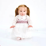 Doll with blonde hair in pigtails wearing a white dress with pink accents.