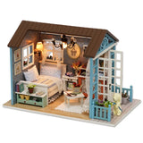 Miniature dollhouse with detailed interior and furniture on a white background