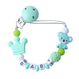 Mint green baby teether with bear and crown design on a white background